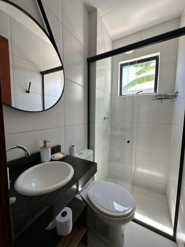 uma casa de banho com um lavatório, um WC e um espelho. em Casa New York em Aquiraz