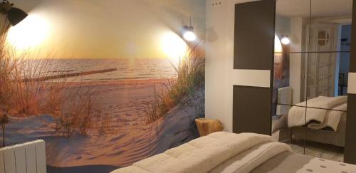 1 dormitorio con un mural en la pared de una playa en Pomme de Pin et Mimosa, en Grand-Village-Plage
