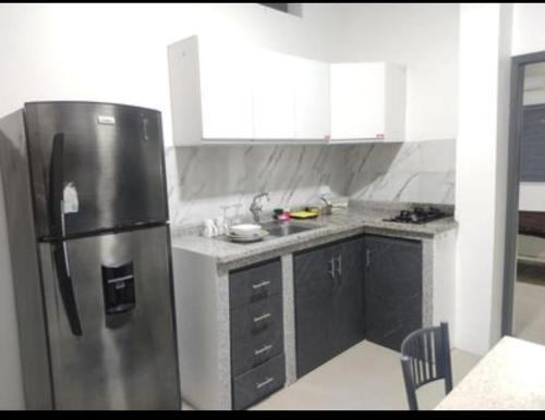 una cocina con nevera de acero inoxidable y armarios en SUITE MODERNA E INDEPENDIENTE CON PARQUEO PRIVADO, en Portoviejo