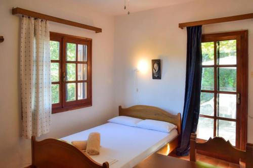 a bedroom with a bed and two windows at Apartment in summer house with large balcony in Chorefto