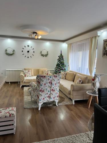 a living room with a couch and a christmas tree at Montana House Njeguši in Cetinje