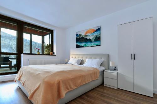 una camera bianca con un letto e una finestra di Best View Ap with Parking And 2 Bathrooms a Sinaia