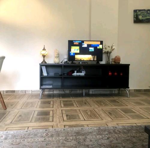 a living room with a tv on a black entertainment center at Göcek quaite private appartment in Fethiye