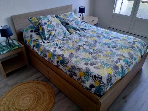a bedroom with a bed with a floral comforter at Appartement T2 tout équipé à 100m de la mer in Saint-Philibert