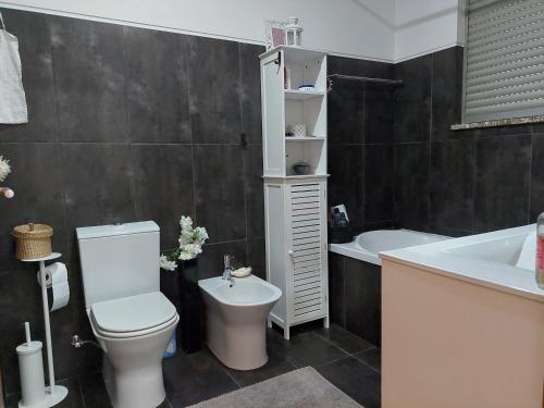 a bathroom with a toilet and a sink and a tub at Cottage, Casa do Laranjal - Near Gerês in Geres