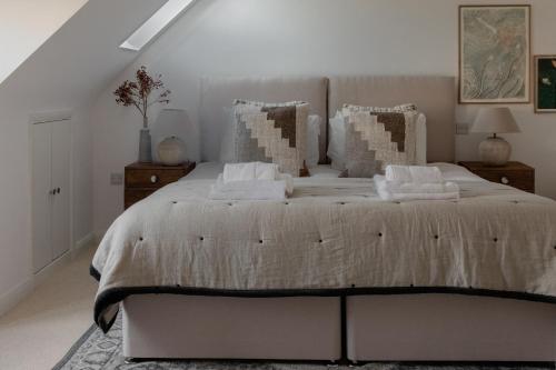 a bedroom with a large bed with pillows at Luxury Eton Cottage-Design Led in Eton