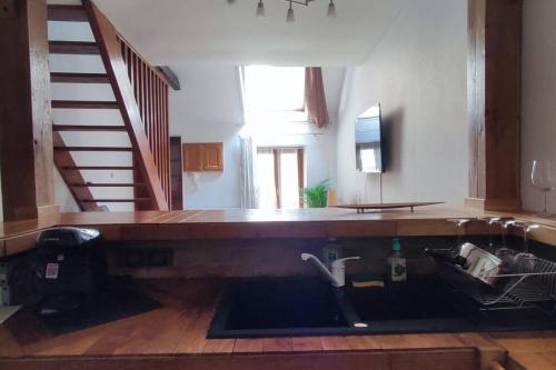 a bathroom with a sink in a room with stairs at Rare coin paisible pour une escapade cosy in Dijon