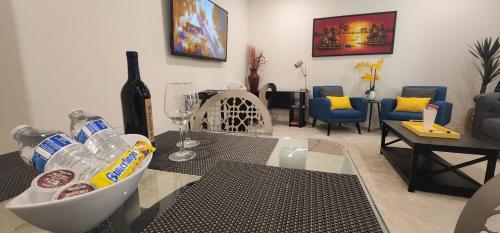 Private Lux Apartment in a new community في فونتانا: غرفة معيشة مع زجاجة من النبيذ وطاولة زجاجية