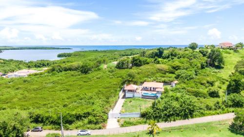 an aerial view of a house on a hill with a lake at Spacieuse villa proche du Vauclin avec piscine privée in Le Vauclin