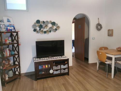 ein Wohnzimmer mit einem Flachbild-TV und einem Tisch in der Unterkunft Il Mare di Delfy in Lido di Ostia
