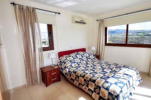 een slaapkamer met een bed en een groot raam bij Villa Olivia Coral in Peyia