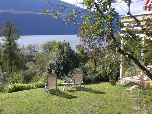 dos sillas sentadas en el césped cerca del agua en Meublé avec jardin au bord lac du Bourget, en Brison-Saint-Innocent