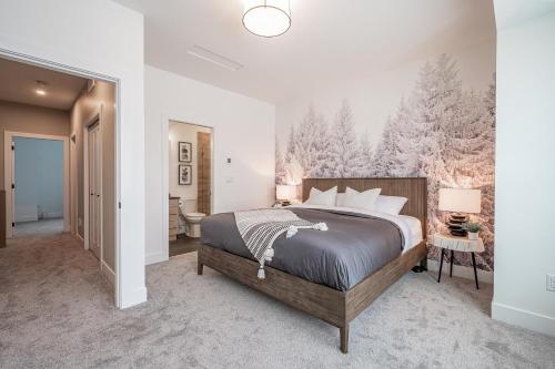 1 dormitorio con 1 cama grande y baño en Grizzly Ridge Getaway Brand New Hot Tub Sleeps 11, en Big White