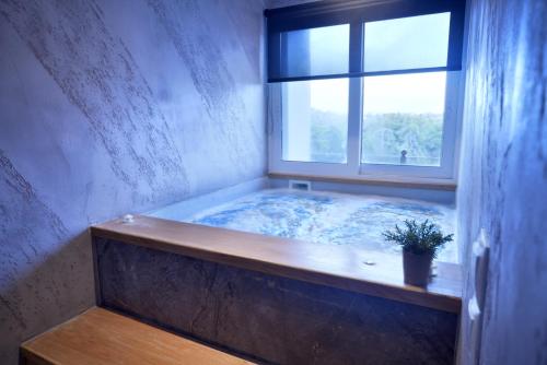 a jacuzzi tub in a room with a window at Anixi Hotel by AP in Athens