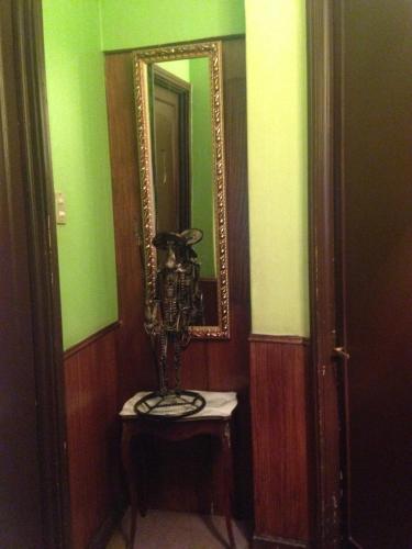 a room with a mirror and a table with a lamp at Hotel La Castellana in Santiago