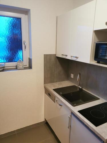 a kitchen with a sink and a window at Riverside Appartements in Lieserbrücke