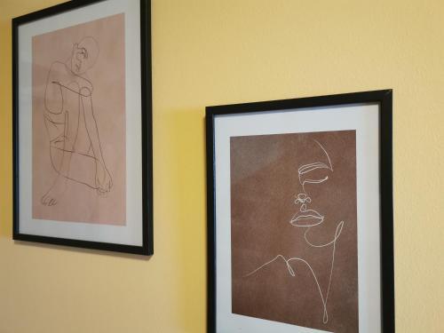 two framed drawings of a man and a woman on a wall at Riverside Appartements in Lieserbrücke
