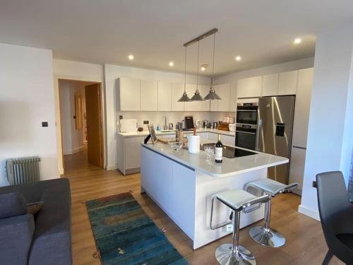 a kitchen with a large white island in a living room at London Bridge flat - perfect for families in London