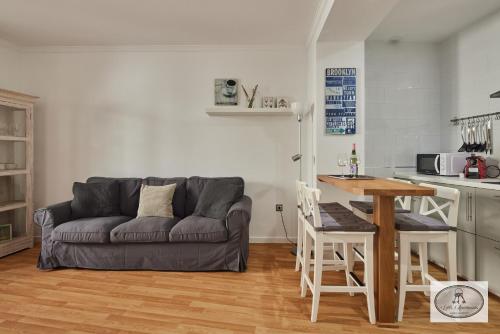 a living room with a couch and a table at Dulce Arbolí Little Apartments in Cádiz