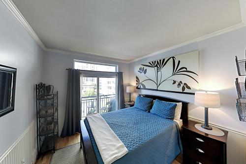 a bedroom with a blue bed and a window at Cityscape Dreams in Seattle