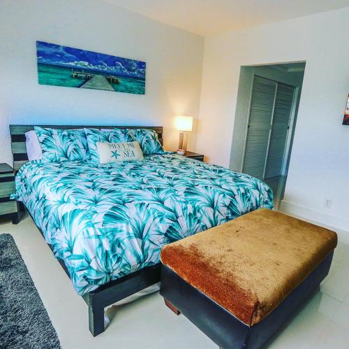 a bedroom with a blue and white bed and a bench at Beautiful penthouse condo with stunning views of both ocean and city in Hollywood