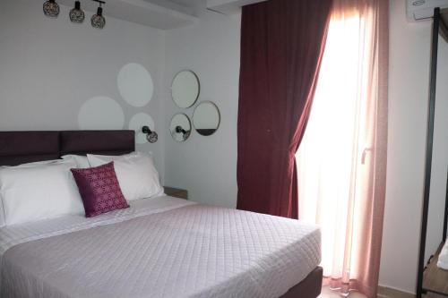 a bedroom with a bed with a purple pillow and a window at OLYMPUS Paradise 2 in Skotína