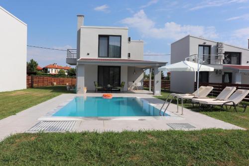 a villa with a swimming pool in front of a house at OLYMPUS Paradise 2 in Skotína