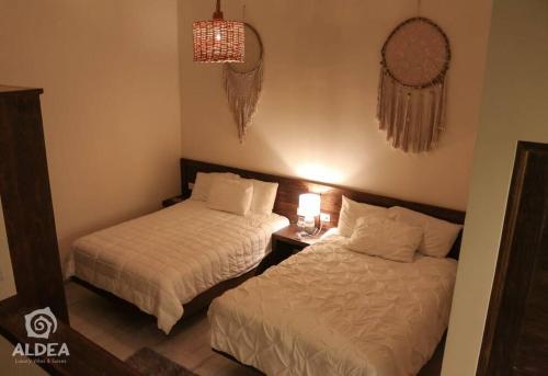 una camera da letto con due letti e un tavolo con una lampada di Villa Naj´Lujosa Alberca privada a San Martín de las Pirámides