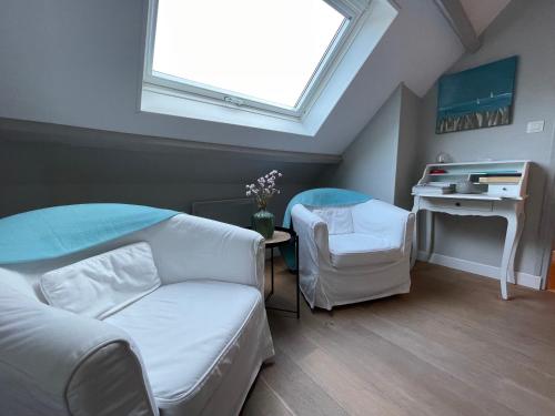 Cette chambre dispose d'un canapé, d'un bureau et d'une fenêtre. dans l'établissement Les Chambres de Souverain Moulin, à Pernes-lès-Boulogne