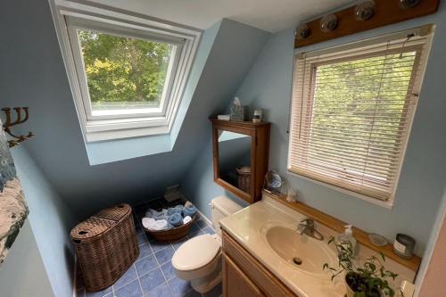 un bagno con lavandino e servizi igienici e due finestre di Harbor Village House a Rockport