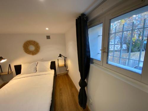 sypialnia z łóżkiem i oknem w obiekcie Loft Rotonde WIFI CLIM SMART TV RUE CALME w Aix-en-Provence