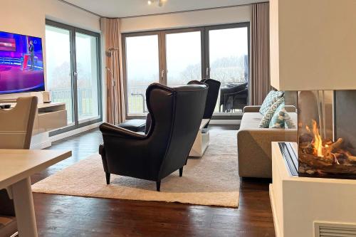 a living room with a chair and a fireplace at Villa Deichgraf 12 "Meerblick" in Börgerende-Rethwisch