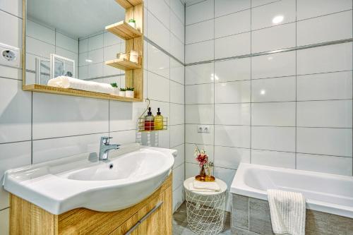 uma casa de banho com um lavatório branco e uma banheira em HAROL Home & Bike em Fertőrákos