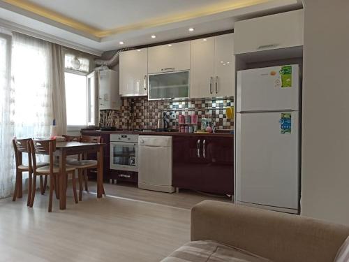 eine Küche mit einem Tisch und einem weißen Kühlschrank in der Unterkunft Klimalı, 2 yatak odası 1 salon in Istanbul