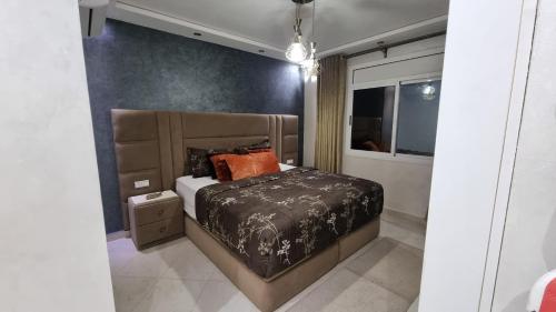 a bedroom with a bed with a black and white comforter at Nador Khattabi 2-18 in Nador