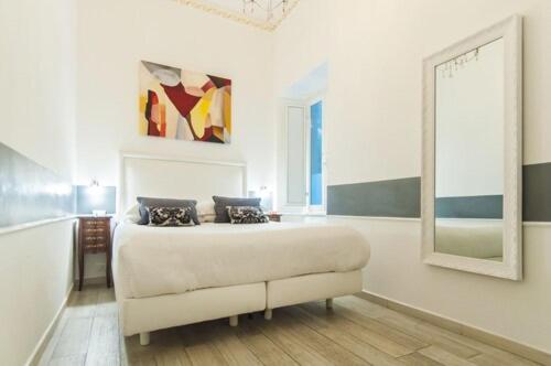 a white bedroom with a bed and a mirror at Ripetta Rooms in Rome