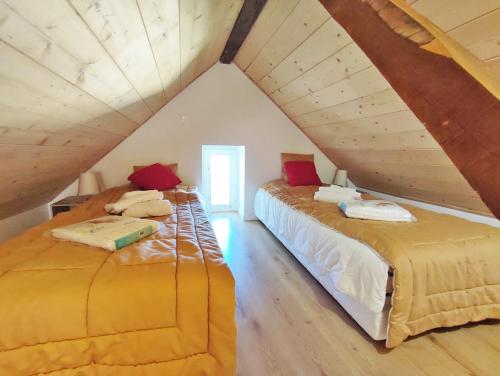 2 Betten in einem Dachzimmer mit Holzdecken in der Unterkunft L'Alexiane, Centre Luchon, parking gratuit, wifi in Luchon