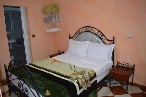 1 dormitorio con 1 cama con colcha blanca en Hotel salem leksor, en Marrakech