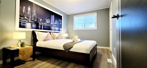 1 dormitorio con 1 cama con una foto en la pared en The Modern Spot en Winnipeg