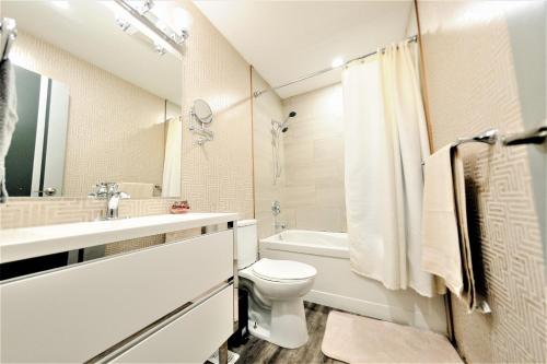 溫尼伯的住宿－The Modern Spot，白色的浴室设有卫生间和水槽。