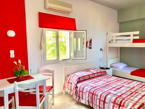Schlafzimmer mit roten Wänden, einem Bett und einem Schreibtisch in der Unterkunft Panorama Apartments in Kastrí