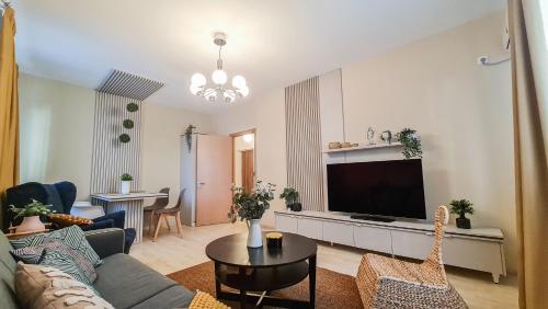 a living room with a couch and a flat screen tv at Orange Onix Apartaments in Bucharest