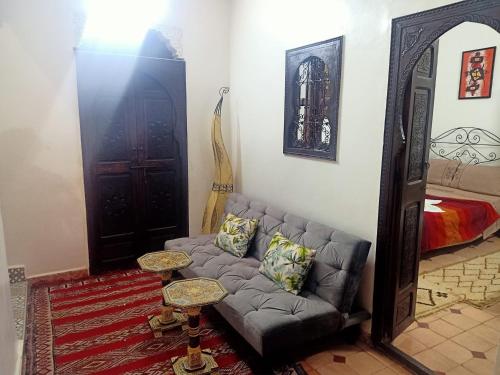 een woonkamer met een bank en een spiegel bij Dar 36 LAKSIBA in Marrakesh