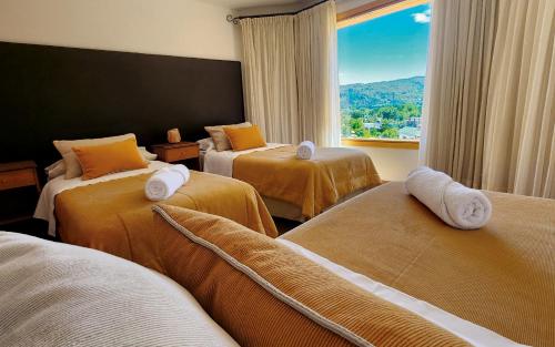 聖馬丁德洛斯安第斯的住宿－Huilko，酒店客房设有三张床和窗户。