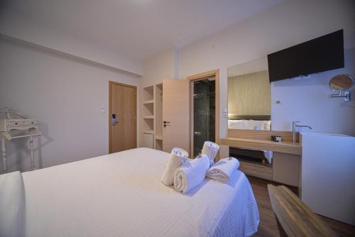 a hotel room with a bed with towels on it at Anixi Hotel by AP in Athens