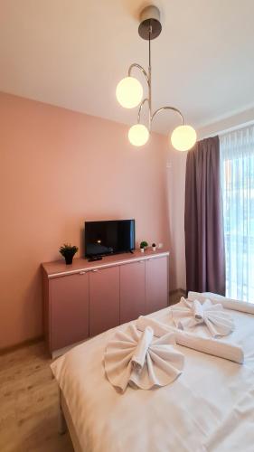 a bedroom with a bed with white sheets and a tv at Orange Onix Apartaments in Bucharest