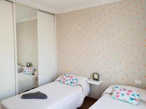 Pokój z 2 łóżkami i lustrem w obiekcie Villa El Olivo del Sur w Aronie