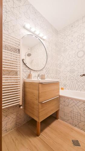 a bathroom with a sink and a mirror and a tub at Orange Onix Apartaments in Bucharest