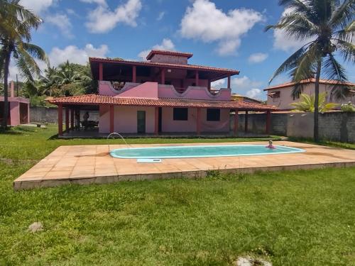 ein Haus mit einem Swimmingpool davor in der Unterkunft Casa veraneio em Canto de Arembepe in Camaçari