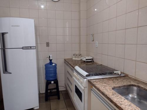 a kitchen with a stove and a sink and a refrigerator at Apartamento Praia do Forte Familiar com piscina in CFB